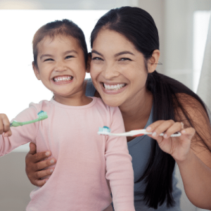 Mother and daughter brushing teeth for oral health and general well-being