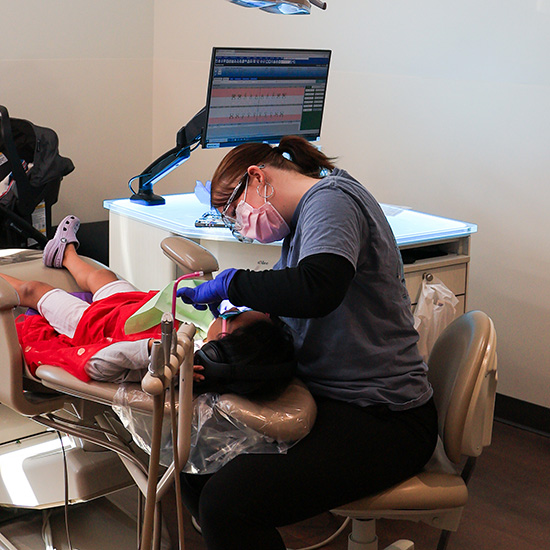 Dental Assistant performing treatment to young child