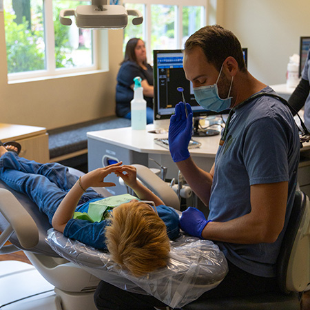 pediatric dentist explaining to child the steps in their treatment