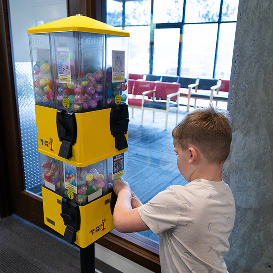 Child using in office toy machine to get a small toy
